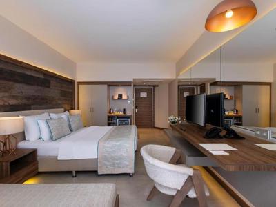 Habitación de hotel moderna con cama doble, escritorio y televisión.