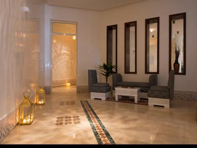 Corridor elegante dell'hotel con area salotto, lanterne dorate e specchi decorativi a parete.