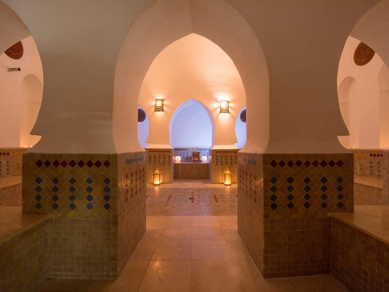 Interno caldo e illuminato con archi e pareti piastrellate tradizionali.