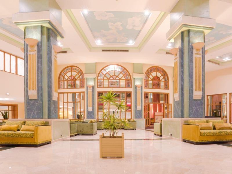 Hall d'hôtel lumineux et spacieux avec coins salon et grandes fenêtres.