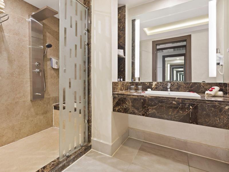 Moderner Badezimmerspiegel reflektiert sich unendlich, mit braunem Marmor-Waschbecken und Duschbereich.