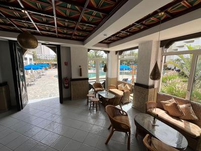 Interior luminoso con muebles de madera y vista a una piscina.