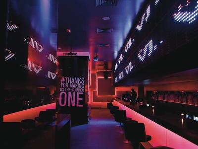 Modernes Hotelbar-Interieur mit dunkler Beleuchtung und roten Neonlichtern.