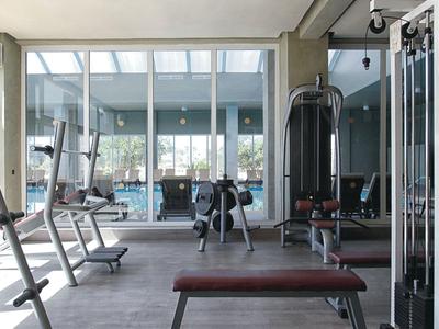 Salle de sport avec équipements modernes et grandes fenêtres donnant sur l'extérieur.