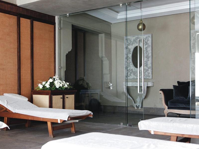 Espace bien-être moderne avec chaises longues et mur en verre dans un hôtel.