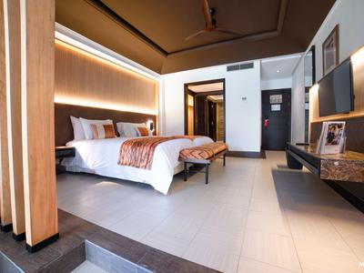Moderne hotelkamer met groot bed, indirecte verlichting en houten kamerverdelers.