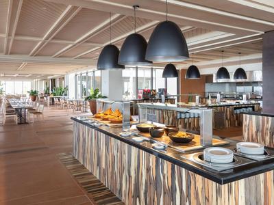 Modernes Buffet in einem hellen Hotelrestaurant mit eleganter Einrichtung und großer Fensterfront.