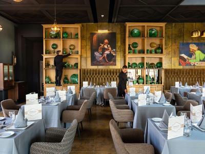 Elegantes Restaurant mit gedeckten Tischen und moderner Holzdekoration an der Wand.