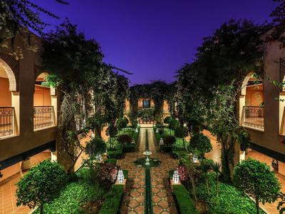 Hotel courtyard with green pathways and two floors under a blue night sky.