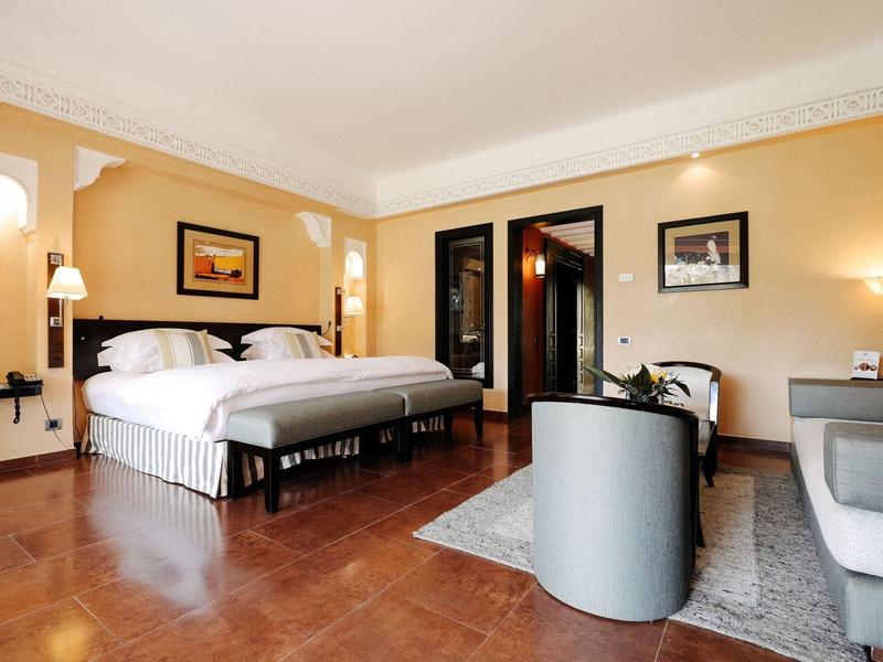 Geräumiges Schlafzimmer mit großen Betten, Holzboden und warmen gelben Wänden, modern eingerichtet.