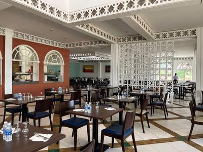 Przestronna, elegancka sala jadalna w hotelu z nakrytymi stołami i nowoczesnymi krzesłami.