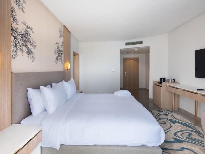 Restaurant mit Backsteinbögen, runden Tischen, beige Stühlen und warmem Licht.