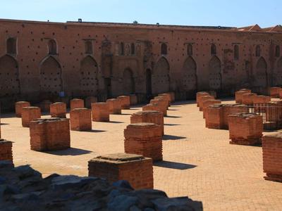 Alter römischer Innenhof mit quadratischen roten Steinsäulen und großer Backsteinmauer