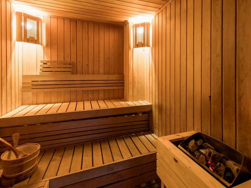 Sauna confortable avec intérieur en bois et poêle chauffant.