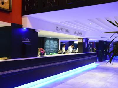 Moderne Hotelbar mit heller Beleuchtung und elegantem Tresen sorgt für einladende Atmosphäre.
