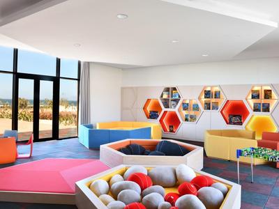 Modern, colorful play and lounge area in a hotel with large windows and views.