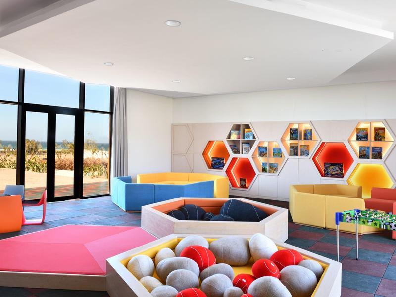 Modern, colorful play and lounge area in a hotel with large windows and views.