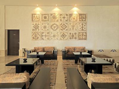 Modern eingerichteter Hotel-Lounge-Bereich mit Sofas, Sesseln und dekorativen Wandfliesen.