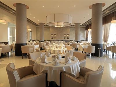 Elegantes Restaurant mit rund gedeckten Tischen und beigen Polsterstühlen