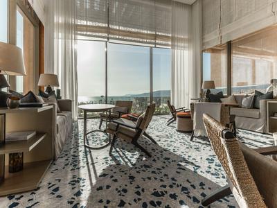 Heller, moderner Hotellounge-Bereich mit großen Fenstern und Blick auf eine Terrasse.