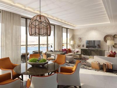 Moderner Hotelzimmer-Lounge-Bereich mit Sitzgelegenheiten und Meerblick durch große Fenster.