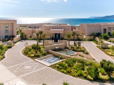 Moderner Hotelkomplex mit Gartenanlagen und Blick auf das Meer bei klarem Himmel