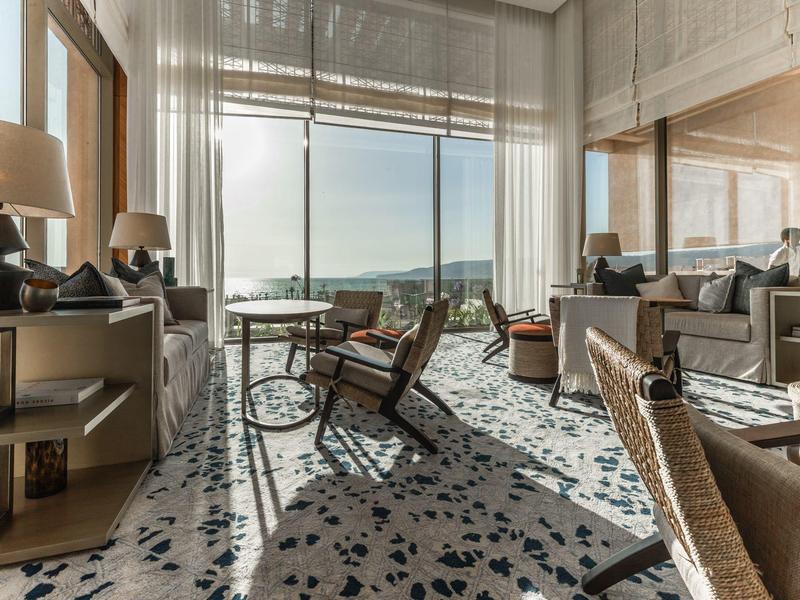 Elegante hotel/lounge met grote ramen en designer terrazzo vloer.