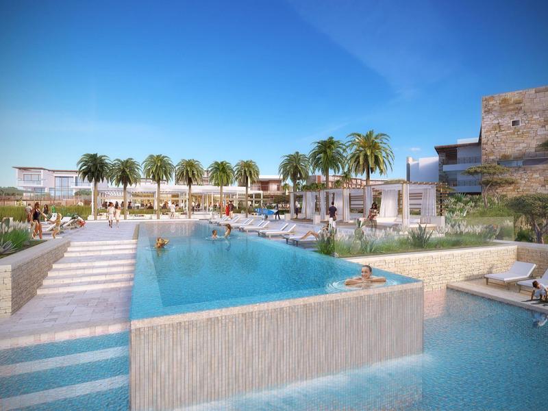 Moderne zwembadomgeving met ligstoelen, palmbomen en hotelgebouwen onder een blauwe lucht.