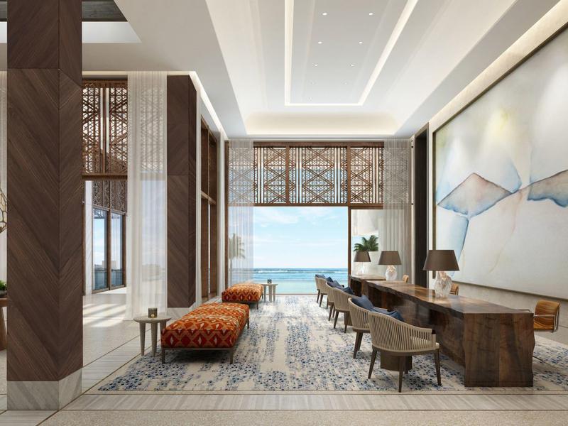 Luxe hotelzitruimte met modern meubilair en uitzicht op zee door grote ramen.