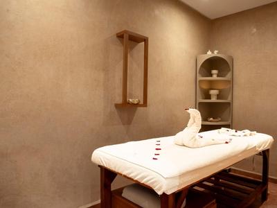 Ein ruhiger Wellnessraum mit Massagetisch, warmer Beleuchtung und entspannter Atmosphäre.
