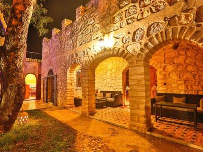 Hotel illuminato con muri in pietra e archi di notte.