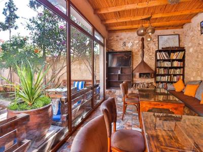 Accogliente zona lounge dell'hotel con grandi finestre, poltrone in pelle, divani e libri.