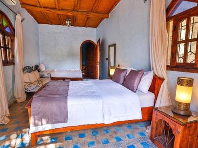 Camera d'hotel accogliente con letto grande, mobili in legno e luce calda.