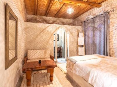 Camera accogliente con soffitto in legno, pareti in pietra e un comodo letto matrimoniale.