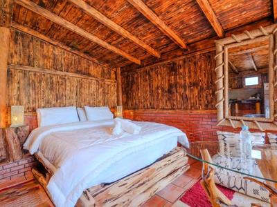 Camera d'hotel rustica con rivestimento in legno e un accogliente letto matrimoniale.