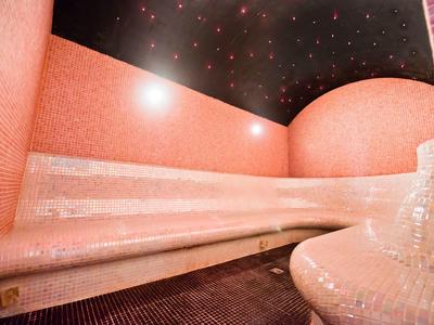 Een luxe oranje spa met zitbank en een sterrenhemel aan het plafond.