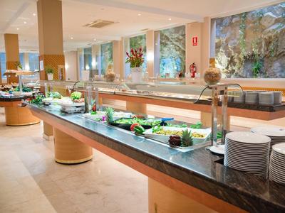 Buffet met verse salades en borden in een lichte hotel eetruimte.