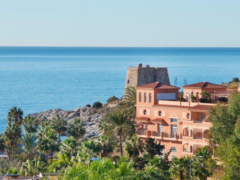 Kusthotel met uitzicht op de rustige blauwe zee en een historisch fort.