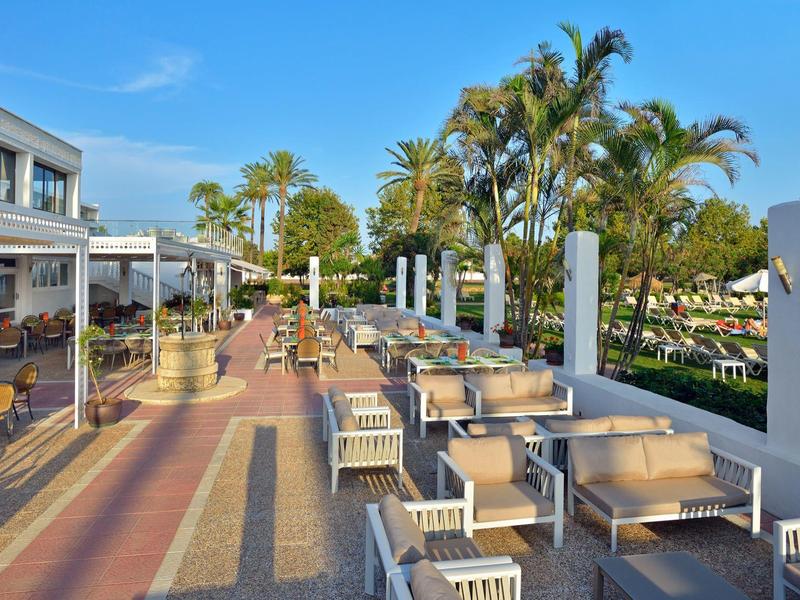 Terrazza esterna con tavoli e sedie sotto un cielo sereno.