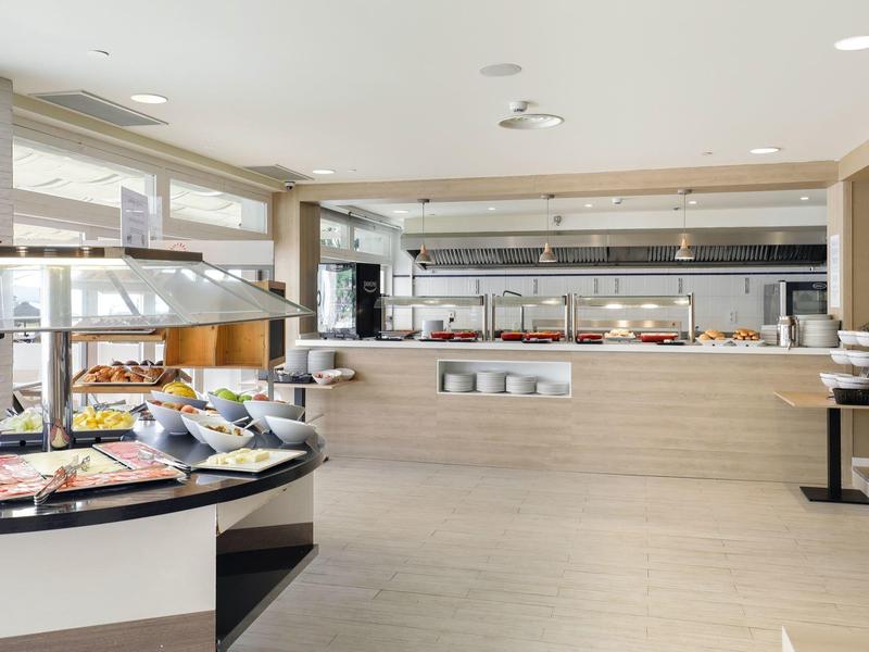 Buffet moderno con selezione di piatti freddi in uno spazio luminoso e ampio.