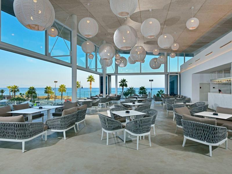 Moderní restaurace s výhledem na moře a velkými okny.