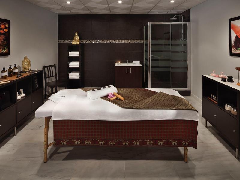 Modern ingerichte wellnessruimte met massagetafel, handdoeken en ontspannen sfeer.