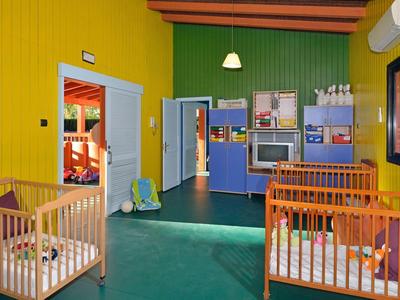 Barevný dětský pokoj s postýlkami a hračkami v hotelu nebo rekreačním domě.