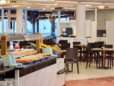 Buffetbereich mit vielfältiger Speisenauswahl und Tischen in einem hellen Hotelrestaurant.