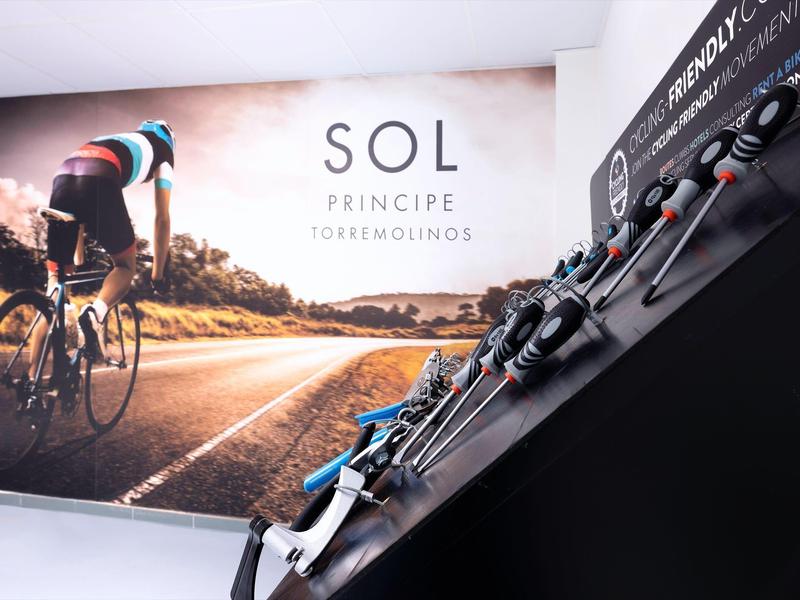 Moderní kola řada před zdí s plakátem sluneční cyklistiky.