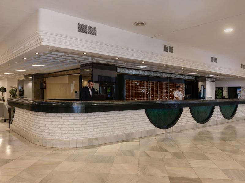 Reception d'hotel moderna con pavimento in marmo lucido e banco curvo.