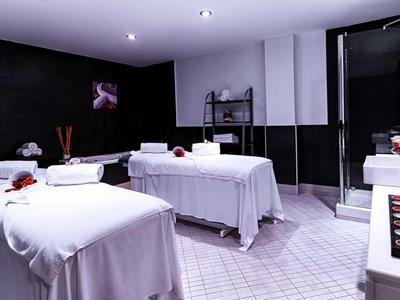 Modern spa with two massage tables, white towels, and a relaxing atmosphere.