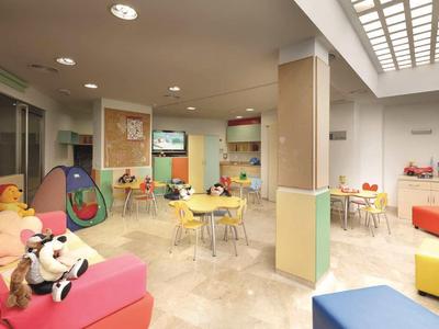 Children's area with colorful tables, chairs, and toys in a hotel or vacation home.