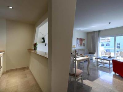 Modern open living and kitchen area with red armchair and plenty of natural light.