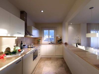 Modern kitchen with wooden countertops and white cabinets in a bright hotel room.
